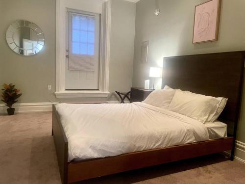 1 dormitorio con 1 cama con sábanas blancas y ventana en Urban Retreat: 2BR in DWTN HBG en Harrisburg