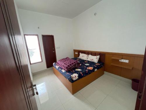 Monga Hotel & Paradise في Hanumāngarh: غرفة نوم صغيرة بها سرير ونافذة