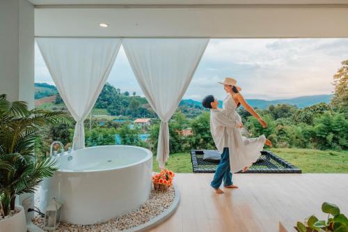 a woman dancing next to a tub in a house at เฌอปือ เชียงใหม่ Cherpue Chiangmai in Ban Mae Na