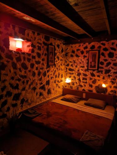 a room with a bed in a stone wall at Buena Vista, Sea View Apto de Oasis Vasiliko , La Asomada in Tías