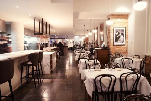 a restaurant with white tables and chairs in a room at InterContinental Melbourne The Rialto by IHG in Melbourne