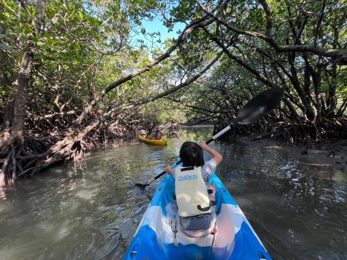 a young girl paddling a kayak on a river at Ecostay Glamping Rainbow Forest in Ishigaki Island