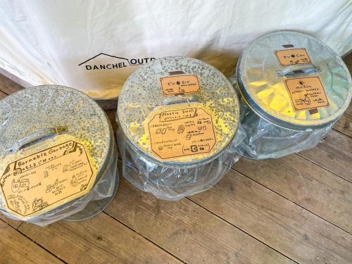 a group of four plastic containers with signs on them at Ecostay Glamping Rainbow Forest in Ishigaki Island