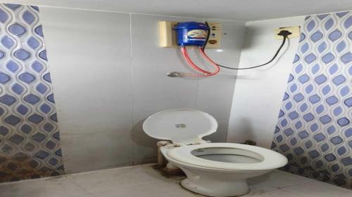 een badkamer met een toilet en een brandblusser bij SPOT ON Hotel VIP Inn in Jamnagar