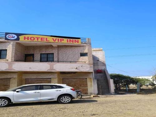 een witte auto geparkeerd voor een hotel VIP Inn bij SPOT ON Hotel VIP Inn in Jamnagar