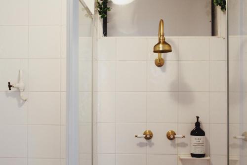 een badkamer met een douche en een fles wijn bij FORR64 - Cosy East Perth Retreat in Perth