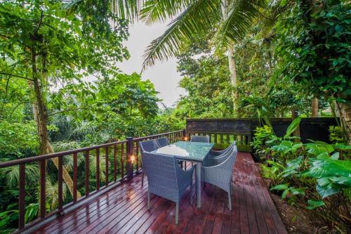 a wooden deck with a table and chairs on it at Luxury 3BR Infinity Jungle View Aashaya Villa Ubud in Ubud