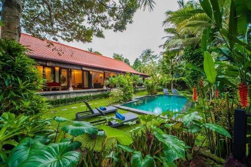 a villa with a swimming pool in a garden at Luxury 3BR Infinity Jungle View Aashaya Villa Ubud in Ubud