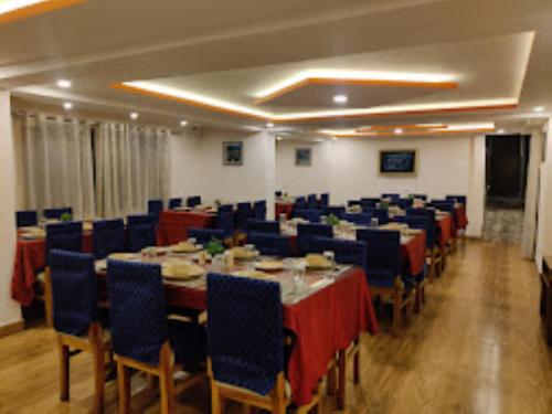 een vergaderzaal met tafels en blauwe stoelen bij Hotel Kasturi Palace & Restaurant Darjeeling in Darjeeling