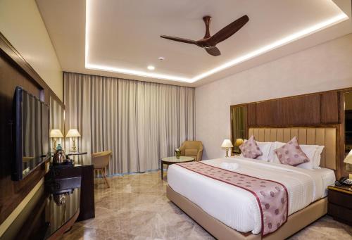 Habitación de hotel con cama y TV en UVA MANISH, en Kundapur