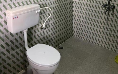 a bathroom with a white toilet in a room at Koilee Homestead by StayApart in Darjeeling