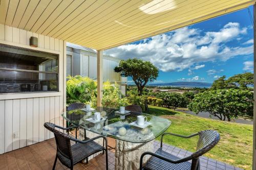 an outdoor patio with a glass table and chairs at Stunning ocean view! 2-2 in the heart of Wailea in Wailea