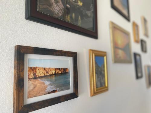 a picture frame hanging on a wall with pictures at Wadi shab guest house in Ţīwī