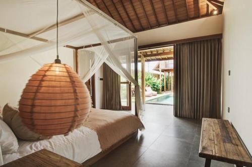 a bedroom with a large bed with a chandelier at Villa Sunshine in Munggu