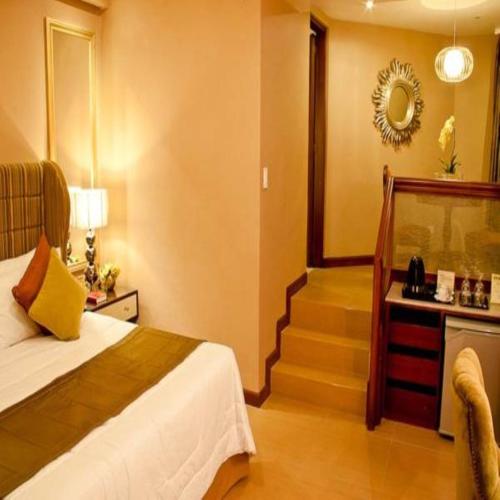 a hotel room with a bed and a staircase at Royal Garden Hotel in Ozamis