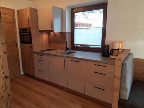 a kitchen with a sink and a window at Haus Traudl in Mayrhofen