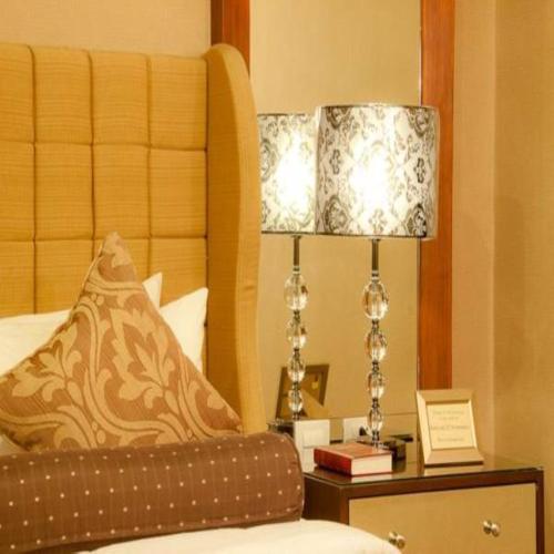 a bedroom with a bed and a lamp on a nightstand at Royal Garden Hotel in Ozamis