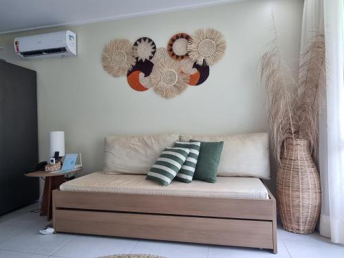 uma sala de estar com um sofá com almofadas e uma decoração de coração em Beach Class Resort 2 quartos Muro Alto BMS em Porto de Galinhas