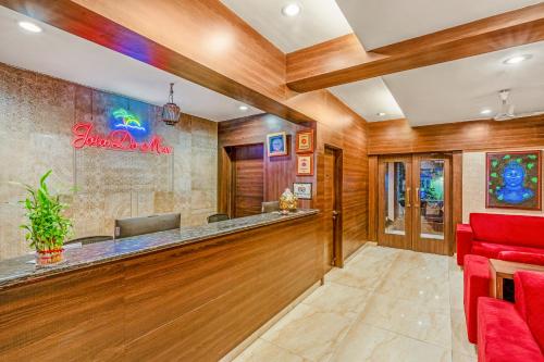 a bar in a hotel lobby with red chairs at Joia Do Mar Resort - Calangute in Calangute