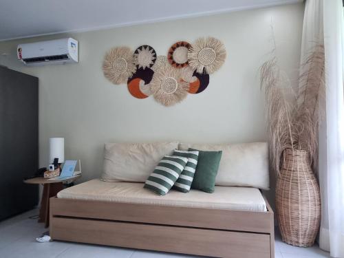 a couch in a living room with a heart decoration on the wall at Beach Class Resort 2 quartos Muro Alto BMS in Porto De Galinhas