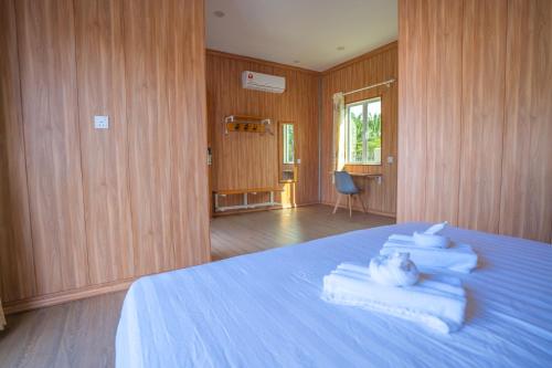 a bedroom with a blue bed with towels on it at Rich Villa 度假庄园 in Semporna