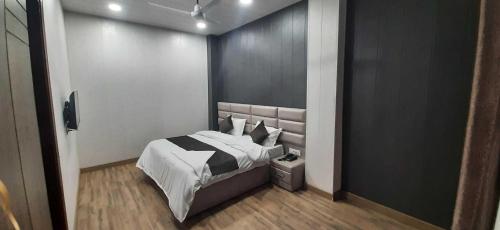 una camera da letto con un letto bianco e nero di OYO HOTEL BLISS a Ludhiana