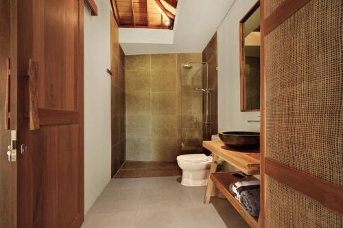 a bathroom with a toilet and a sink at Villa Sunshine in Munggu