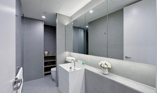 a bathroom with a sink and a toilet and a mirror at 84 Floor/Splendid View/free car park/3B/Near Crown in Melbourne