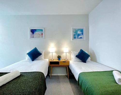 a room with two beds with blue pillows at 84 Floor/Splendid View/free car park/3B/Near Crown in Melbourne