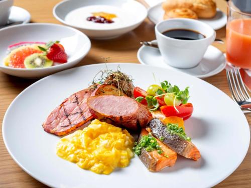 福岡市にあるソラリア西鉄ホテル福岡のコーヒーとテーブルの上に並ぶ朝食用の食品