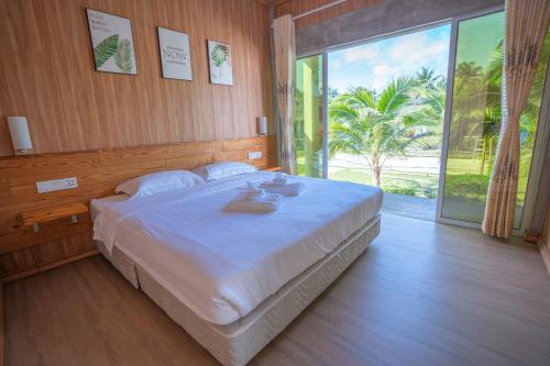 a bedroom with a large bed and a large window at Rich Villa 度假庄园 in Semporna