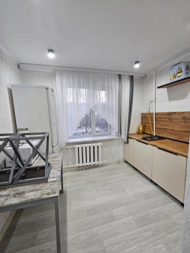 uma cozinha com armários brancos e uma janela em 1 ком квартира ТД Астана em Oral