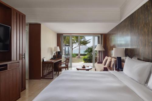a bedroom with a large bed and a living room at Mandarin Oriental, Sanya in Sanya