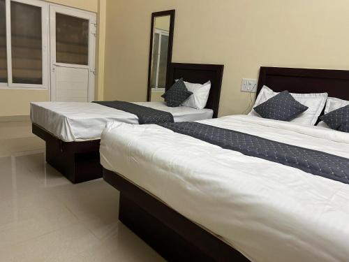two beds in a hotel room with two beds sidx sidx sidx at Nath Palace in Varanasi