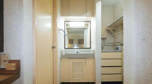 een badkamer met een wastafel en een spiegel bij RedDoorz at Broadway Court Apartelle II Quezon City in Manilla