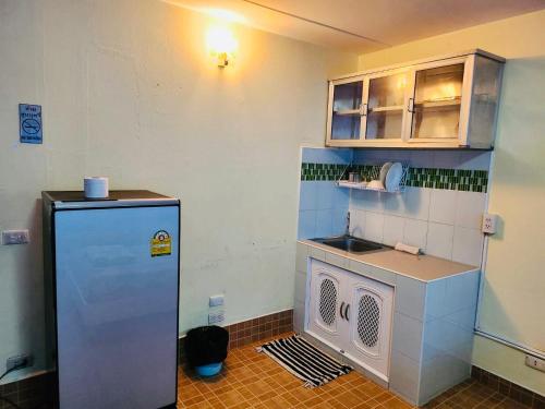 a small kitchen with a refrigerator and a sink at Muangthong C6,C7,C8 near IMPACT in Nonthaburi