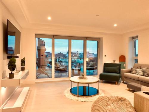 a living room with a couch and a table at Quiet Clifftop luxury apartment with partial seaviews in Newquay