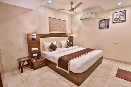 a bedroom with a large bed and a ceiling fan at FabHotel Prime Candlewood by A plus Hospitality in Udaipur