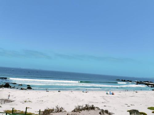 a group of people on a beach with the ocean at Cabañas Tres Islas in Punta de Choros