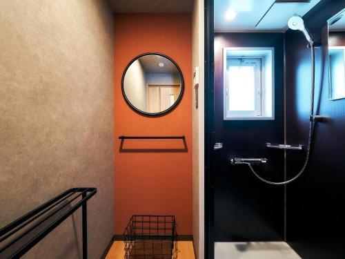 baño con pared de color naranja y espejo en Rakuten STAY Hakata Gion 302 - Rakuten Ichiba Collaboration Room -, en Fukuoka