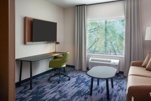 a hotel room with a desk and a couch and a window at Fairfield by Marriott Inn & Suites Hardeeville I-95 North in Hardeeville