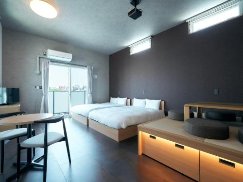 a bedroom with a bed and a desk and a table at Rakuten STAY Hakata Gion 402 Deluxe Room in Fukuoka