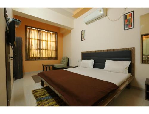 a bedroom with a large bed in a room at Hotel Ronak Royal, Porbandar in Porbandar