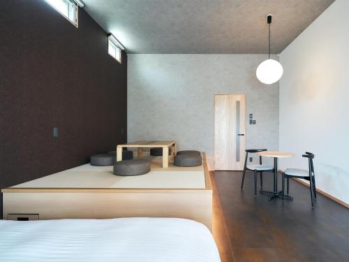 1 dormitorio con 1 cama, mesa y sillas en Rakuten STAY Hakata Gion 502 Deluxe Room, en Fukuoka