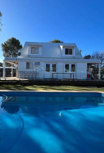 a house with a pool of water in front of it at Gorgeous Country Cottage In Lovely Private Grounds in Scone