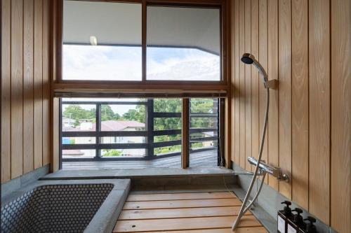 a bathroom with a large window and a bath tub at S-villa Izu Rokkakutei in Ito