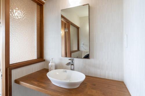 a bathroom with a white sink and a mirror at S-villa Izu Rokkakutei in Ito