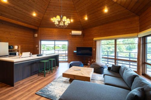 a living room with a couch and a kitchen at S-villa Izu Rokkakutei in Ito