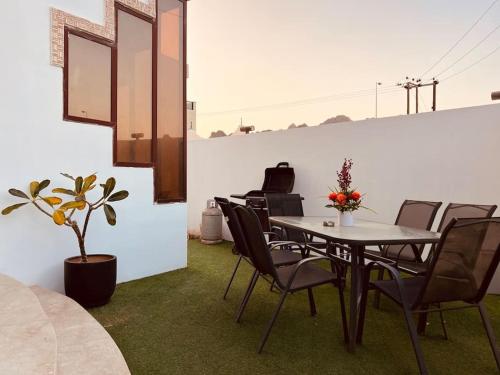 ONE Prestine Beach Villa في مسقط: غرفة طعام مع طاولة وكراسي وبيانو
