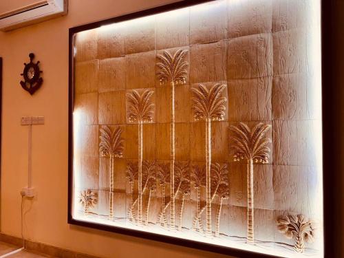 a painting of palm trees on a wall at ONE Prestine Beach Villa in Muscat